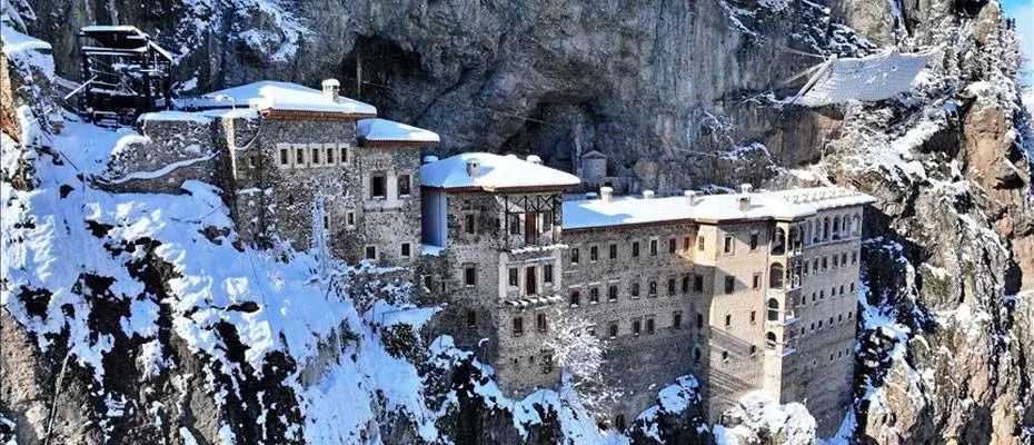Kar örtüsü altındaki Sümela Manastırı ziyaretçilerin ilgisini çekiyor